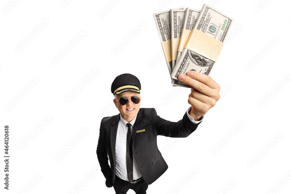Chauffeur in a uniform holding a stacks of money in front of camera Chauffeur in a uniform holding a stacks of money in front of camera