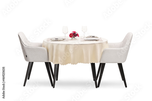 Round restaurant table with a cloth set for two persons photo