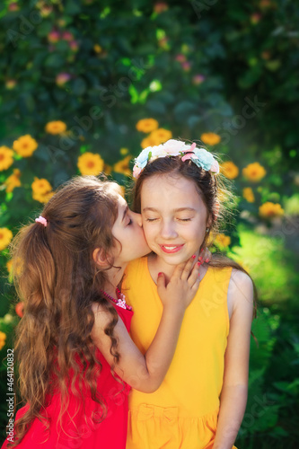 Two Cute little girls embracing and smiling at summer party. Happy kids outdoors. Place for text