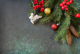 Christmas or New Year flat lay with fir tree branch and Christmas decorations with on a dark green stone background. Holiday concept.