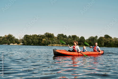 Caucasian family floats on kayak in lake or river