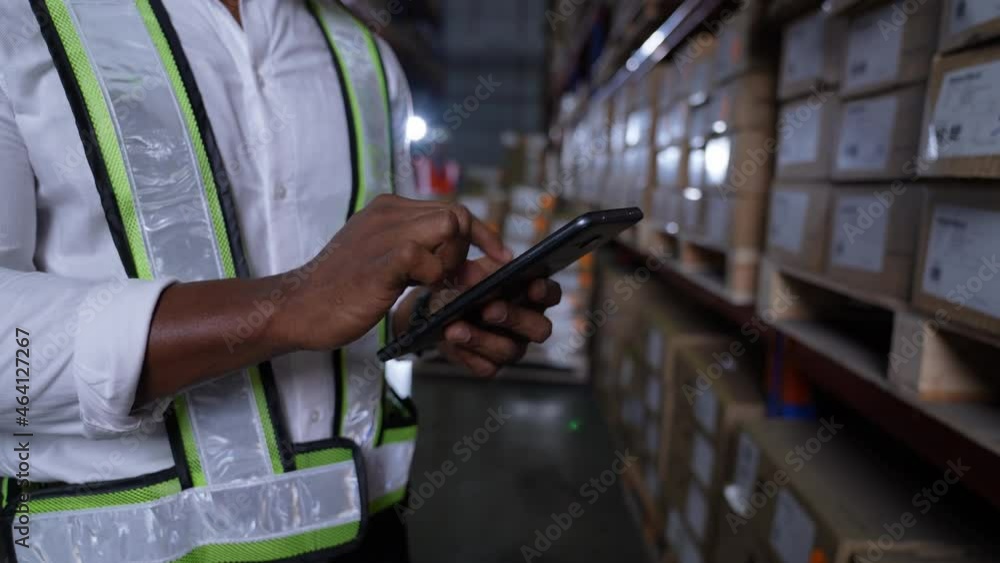 Business concept of 4k Resolution. An employee is checking the goods with a tablet in the warehouse. Business concept of 4k Resolution. An employee is checking the goods with a tablet in the warehouse.