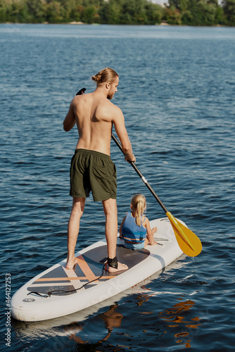 Man riding his little girl on kayak with paddle
