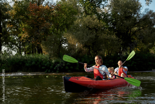 Young resting family floats on kayak at daytime