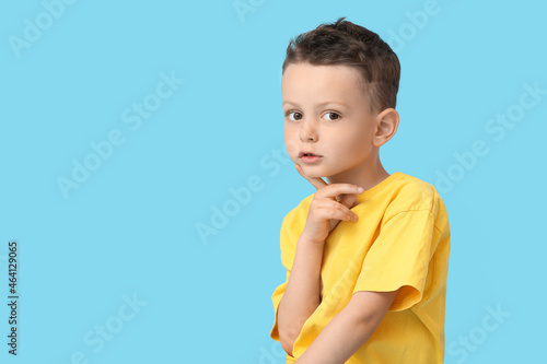 Portrait of cute little boy on color background