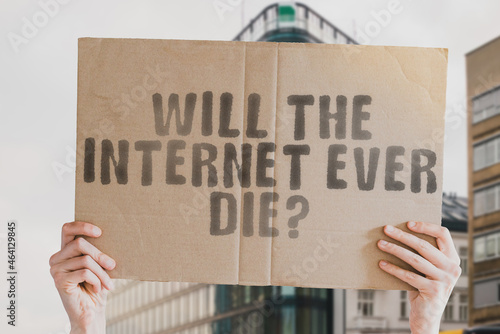 The question " Will the Internet ever die? " on a banner in men's hand with blurred background. Electronics. Future. Evolution. Futuristic. Service. Society. Virtual. Stressful