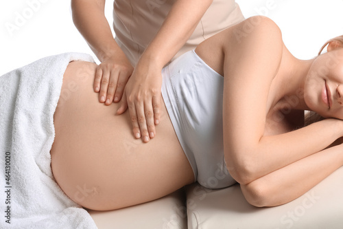Young pregnant woman having massage against white background photo