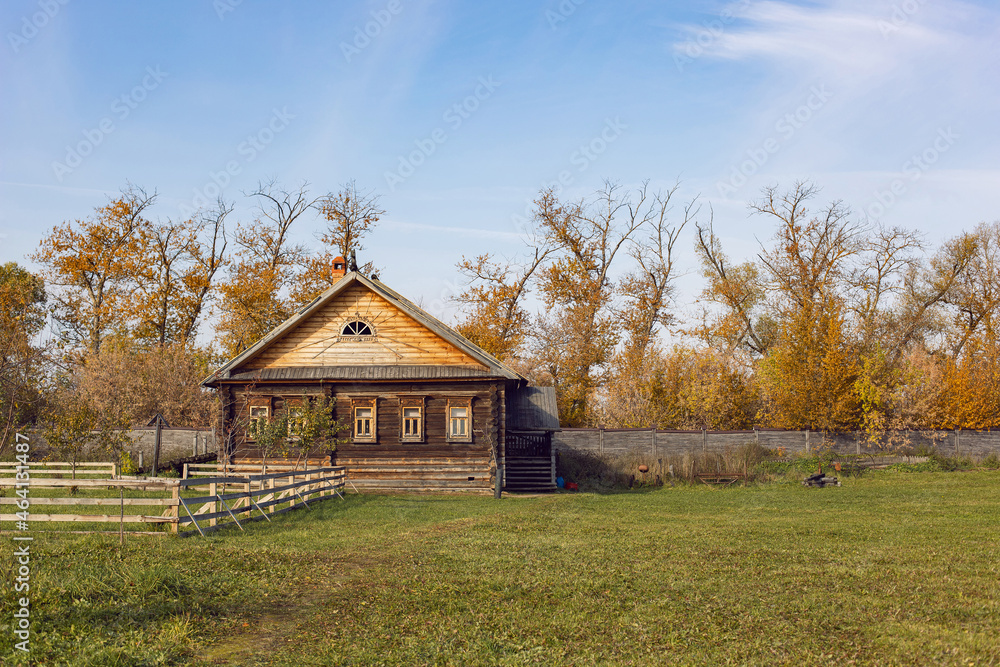 wooden old Russian house in autumn stands on large field