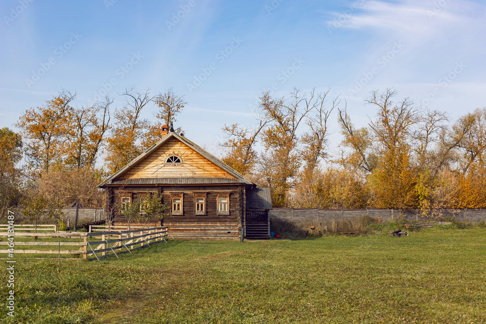 wooden old Russian house in autumn stands on large field wooden old Russian house in autumn stands on large field