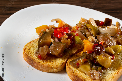 Eggplant appetizer antipasti made with yellow pepper, onion, raisin, and olive oil photo