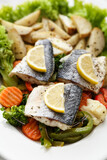 Tasty sea bass fish with vegetables on plate, closeup