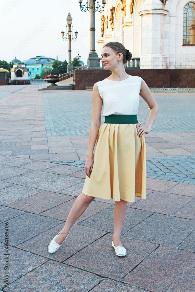 A nice woman in retro beautiful dress posing for camera in the street in Moscow Yellow skirt A nice woman in retro beautiful dress posing for camera in the street in Moscow Yellow skirt