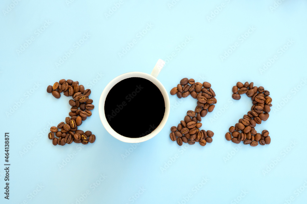 2022 number made of roast coffee beans and cup of coffee on pastel blue background. Happy New Year and Merry Christmas. 2022 number made of roast coffee beans and cup of coffee on pastel blue background. Happy New Year and Merry Christmas.