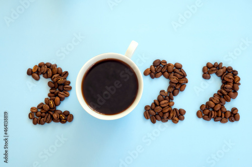 2022 number made of coffee beans and cup of coffee on light blue background as symbol of new start, goals and beginning. Happy New Year and Merry Christmas.