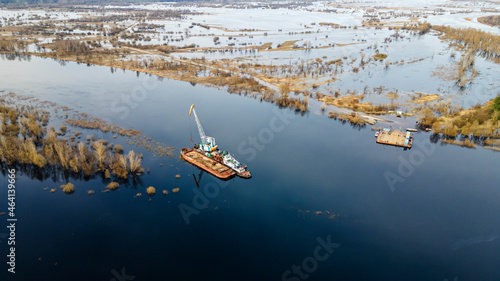 Aerial view of dredge replenish sand in river. Canal is being dredged by excavator. Top view of dredging boat crane. photo