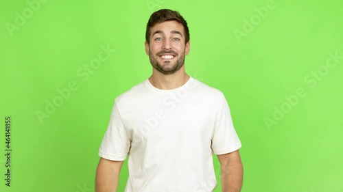 Handsome man saluting with hand with happy expression over isolated background