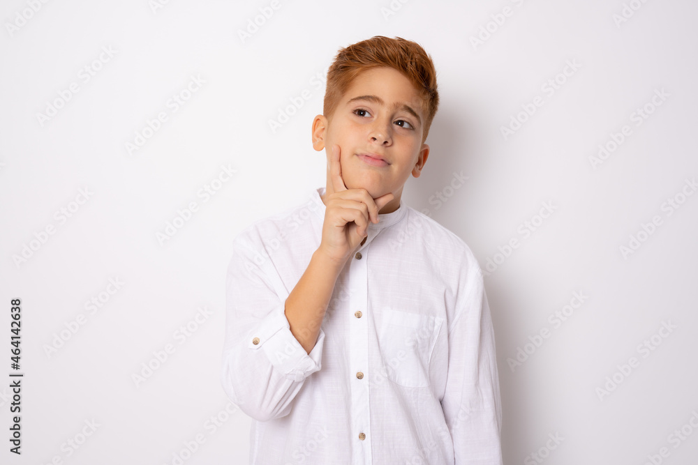 Little redhead boy isolated on white background thinking an idea Little redhead boy isolated on white background thinking an idea