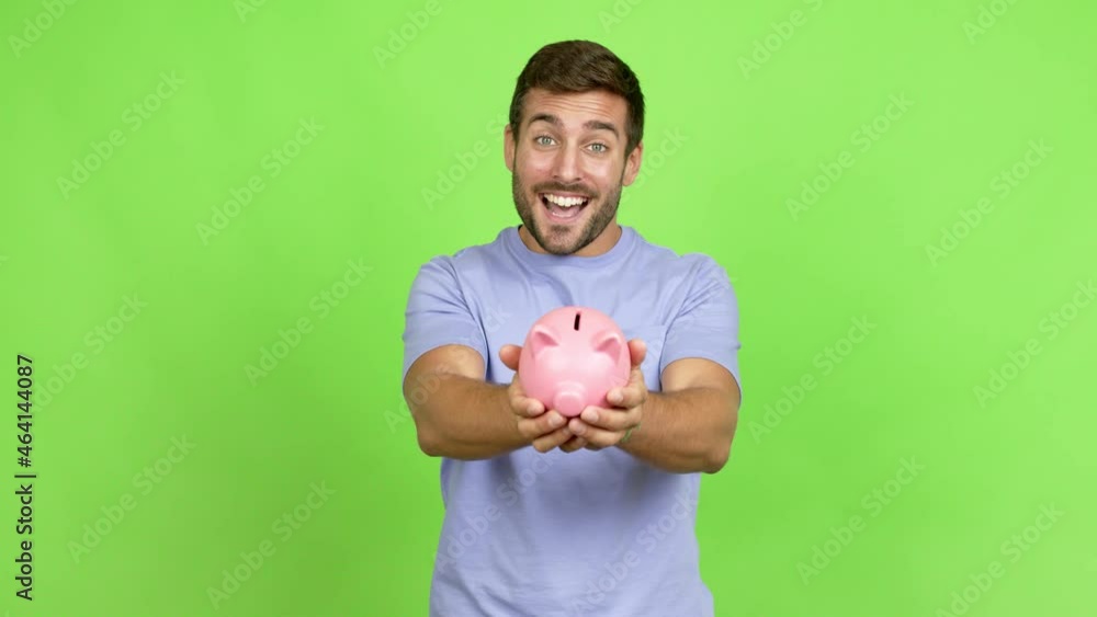 Handsome man happy and holding a piggybank over isolated background Handsome man happy and holding a piggybank over isolated background