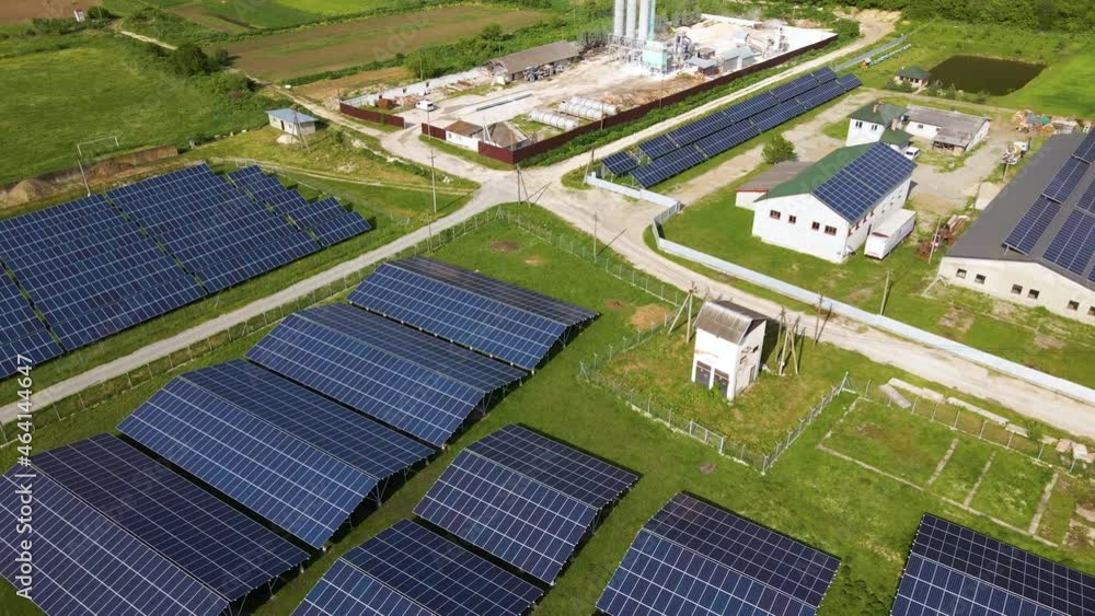 Aerial view of electrical power plant with rows of solar photovoltaic panels for producing clean ecological electric energy at industrial area. Renewable electricity with zero emission concept. Aerial view of electrical power plant with rows of solar photovoltaic panels for producing clean ecological electric energy at industrial area. Renewable electricity with zero emission concept.
