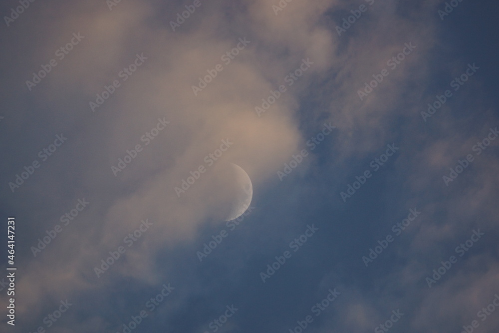 Beautiful Moon crescent amidst white clouds and blue sky