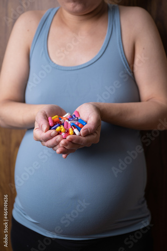 pregnant women holding pills in her hands