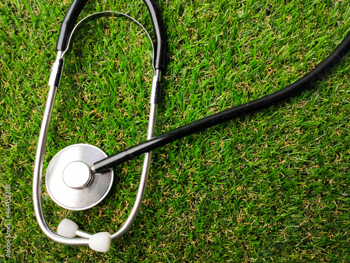 Stethoscope on a green grass with copy space.
