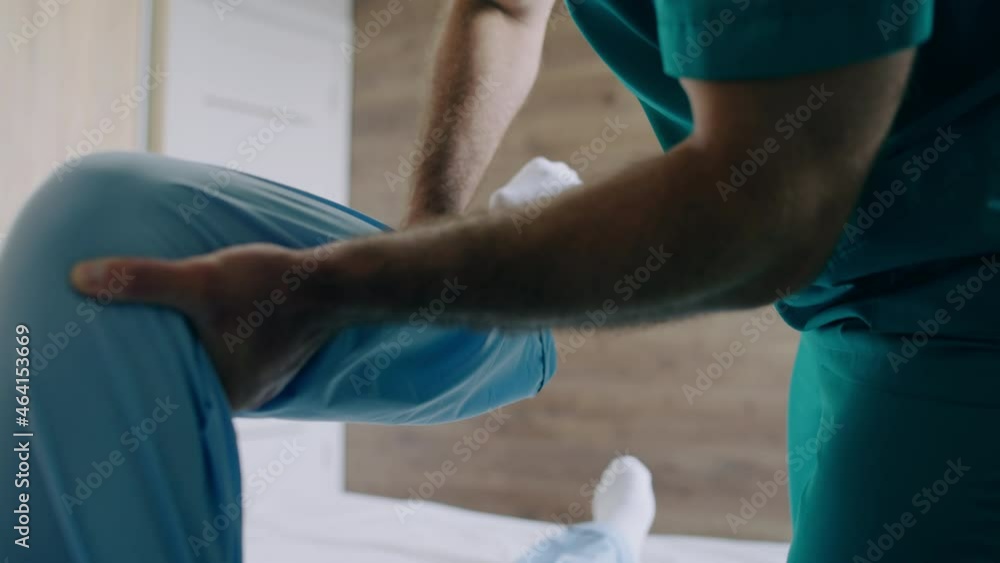 Rehabilitation therapist assisting elderly man, doing physical exercises Rehabilitation therapist assisting elderly man, doing physical exercises