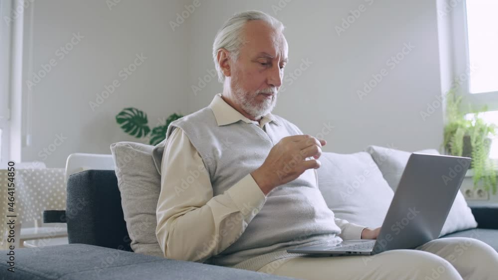 Annoyed senior man learning to use laptop at home, challenge of technology Annoyed senior man learning to use laptop at home, challenge of technology