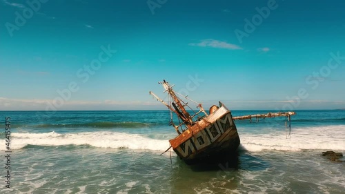 Abandoned Rusty Ship on the Coast of the Pacific Beach in the Summer photo