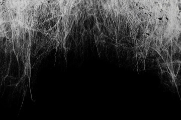 Creepy hanging spider web or cobweb on black, top border. Spooky Halloween or gothic background.