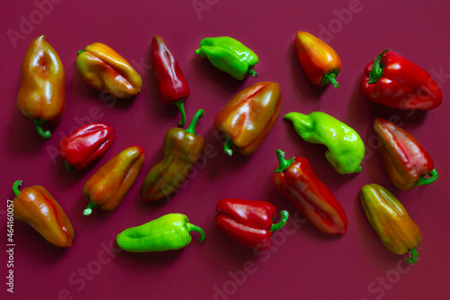 Pattern of bell peppers on the wine red background. Top view. Ecological, Non gmo vegetables