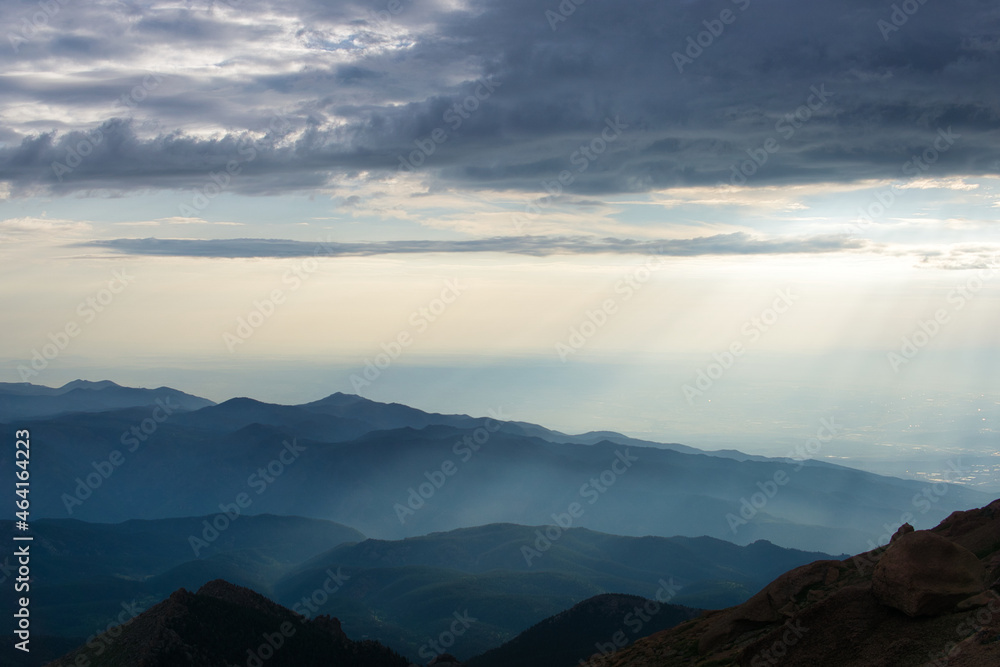 Sunrays over mountains with hazy clouds
