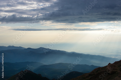Sunrays over mountains with hazy clouds