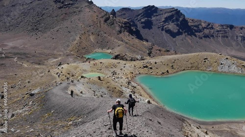 Tourists hike down loose volcanic pumice trail toward Emerald Lakes photo