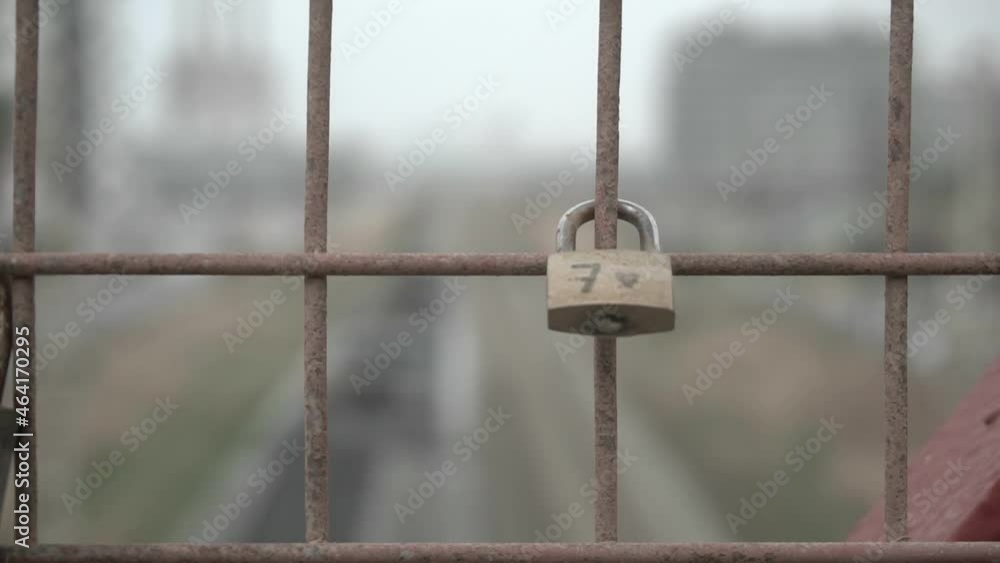 Lonely lucky lock with the number seven on an industrial bridge while the train goes underneath Lonely lucky lock with the number seven on an industrial bridge while the train goes underneath