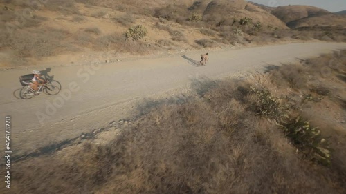 FPV shot weaving through a group of mountain bikers in the desert hills of Mexico. photo