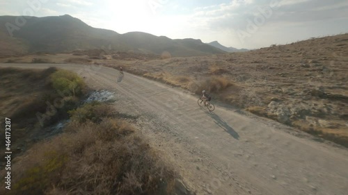 FPV shot weaving through a group of mountain bikers in the desert hills of Mexico.