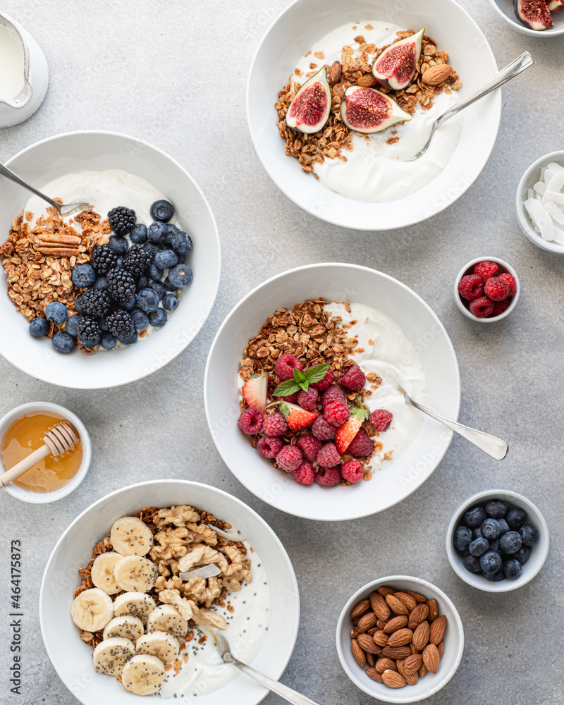 Breakfast, granola with yogurt, berries, fruits and nuts on a light background, view from above Breakfast, granola with yogurt, berries, fruits and nuts on a light background, view from above