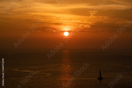 Sunset on the sea and through the clouds over. Tranquil seascape with the horizonal skyline. © Surachetsh