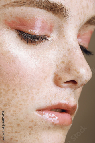 Close up portrait of young with perfect shining skin and freckles