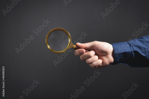 Caucasian businessman holding magnifying glass.