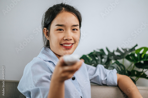 Young woman use romote control at home photo