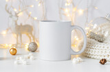 White ceramic tea mug mockup with winter xmas decorations and copy space for your design. Front view 10oz cup background for Christmas promotional content.