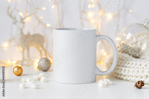 White ceramic tea mug mockup with winter xmas decorations and copy space for your design. Front view 10oz cup background for Christmas promotional content.