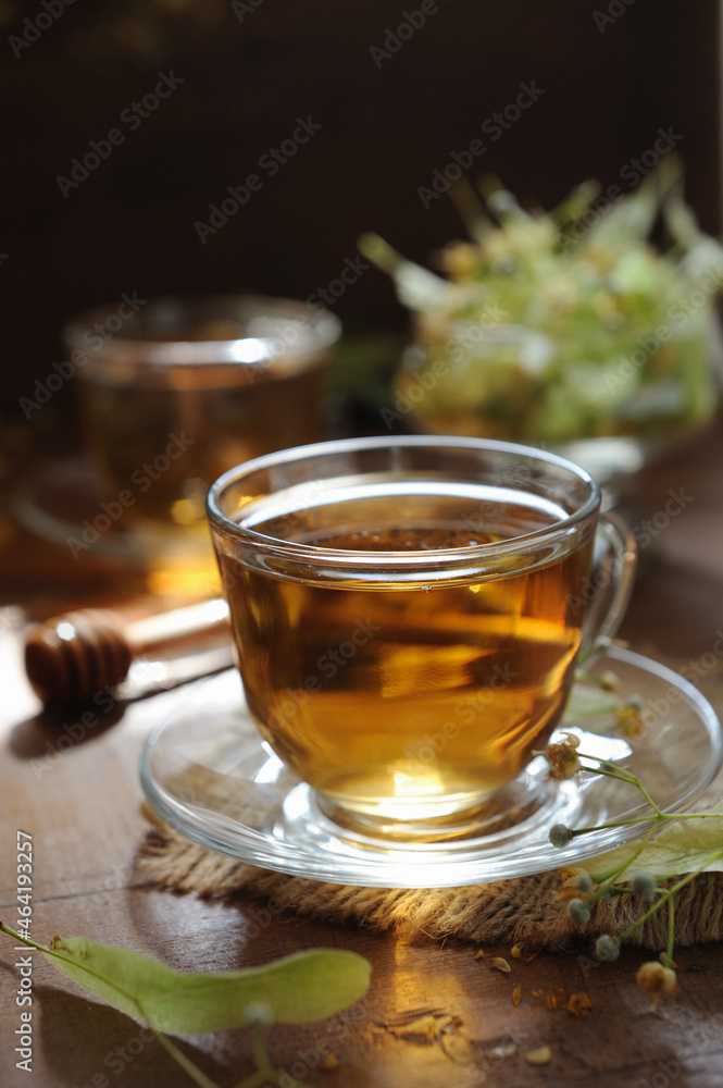 Cups of linden tea on wooden background in sunshine light Cups of linden tea on wooden background in sunshine light