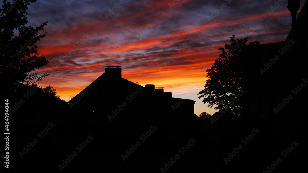 silhouette of a house at sunset with dramatic sky