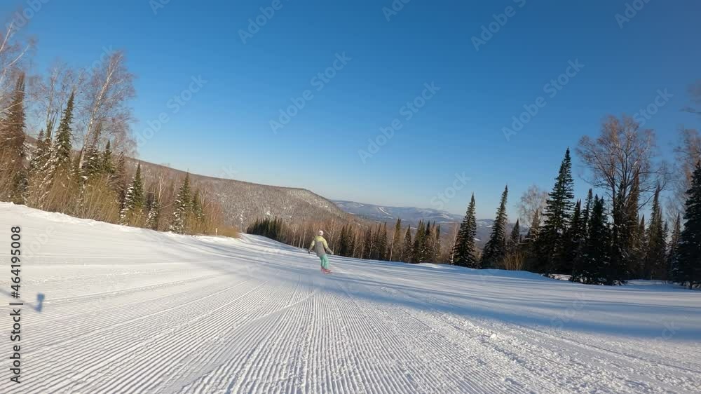 SLOW MOTION: a girl on a snowboard rides in the morning on fresh corduroy on a ski track. second-person view, camera pursuit. the concept of active recreation in winter. 2k prores SLOW MOTION: a girl on a snowboard rides in the morning on fresh corduroy on a ski track. second-person view, camera pursuit. the concept of active recreation in winter. 2k prores