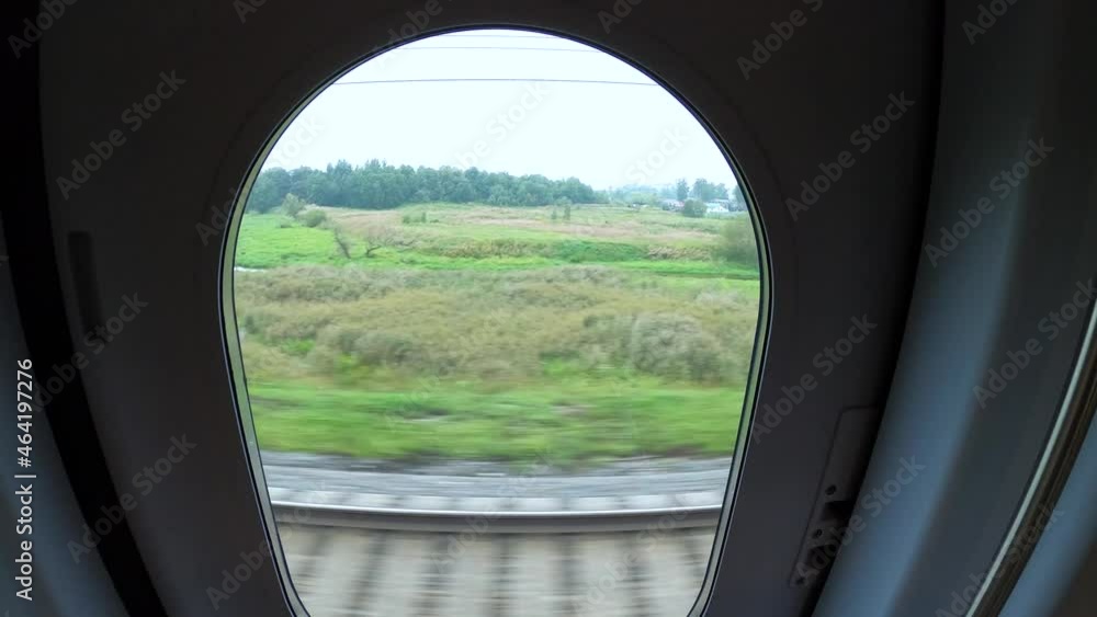 Countryside view from the door window of a traveling train. Countryside view from the door window of a traveling train.