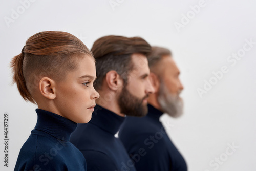 Side view of three generations of men in row