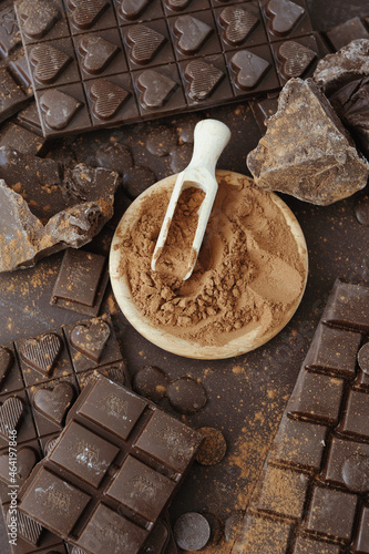 Cacao powder in wooden bowl with chopped and chips of dark chocolate